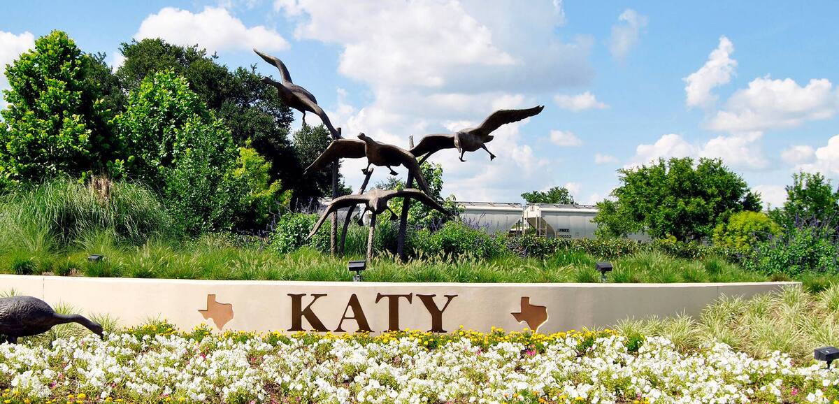 City of Katy sign with bronze geese sculpture and flowers