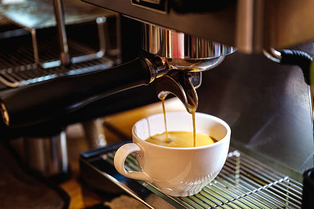 Espresso pouring into a white cup from a coffee machine