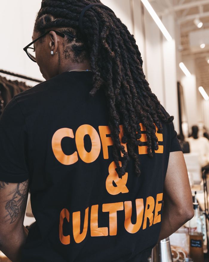 Back of the Visionary Grinders shirt reading Coffee and Culture in orange